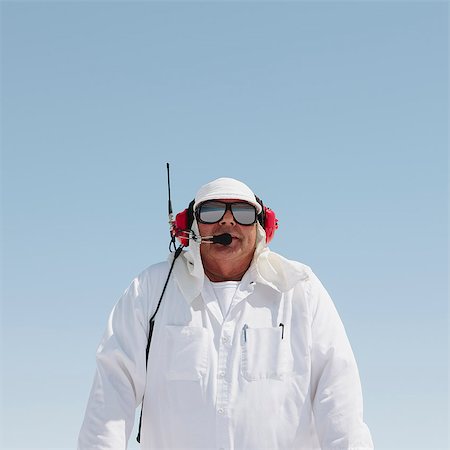 A man in white overalls, with a radio headset, a race official timekeeper at a car racing event, Speed Week. Foto de stock - Sin royalties Premium, Código: 6118-07203241