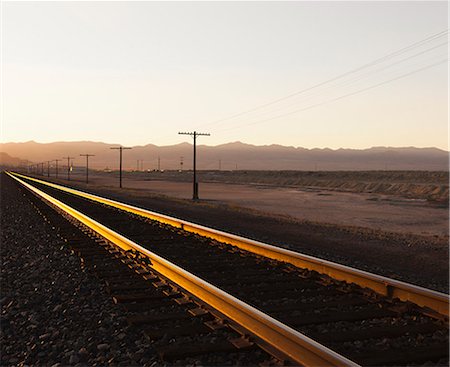 simsearch:6118-08860557,k - Railroad tracks extending across the flat Utah desert landscape, at dusk. Stock Photo - Premium Royalty-Free, Code: 6118-07203246