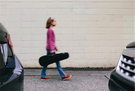 fender - A ten year old girl carrying a violin in a case on an urban street. Stock Photo - Premium Royalty-Free, Code: 6118-07203259