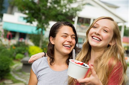 dessert on a white spoon - Two girls hugging and laughing. Stock Photo - Premium Royalty-Free, Code: 6118-07203267