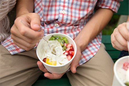 photo preteen dessert - Young people sitting side by side, eating fresh organic fruit and yoghurt desert. Foto de stock - Sin royalties Premium, Código: 6118-07203266