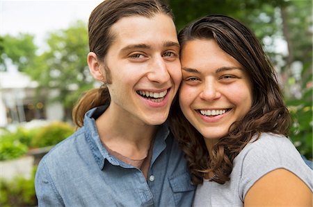 ponytail girls - A young couple side by side, flirting and taking photographs. Stock Photo - Premium Royalty-Free, Code: 6118-07203269