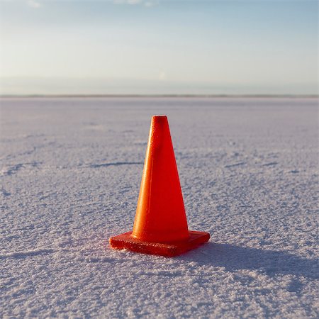 A solitary traffic cone on the white reflective mineral dusted surface of the Bonneville Salt Flats in the early morning light. Stock Photo - Premium Royalty-Free, Code: 6118-07203239