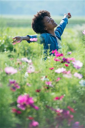 simsearch:6118-08220582,k - A woman standing among the flowers with her arms outstretched. Pink and white cosmos flowers. Foto de stock - Sin royalties Premium, Código: 6118-07203349