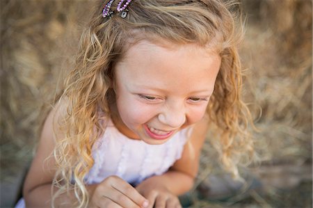 A young girl in a barn laughing. Stock Photo - Premium Royalty-Free, Code: 6118-07203312