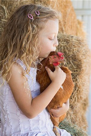 farm animal - A young girl standing in a hay barn holding a chicken in her arms. Stock Photo - Premium Royalty-Free, Code: 6118-07203314