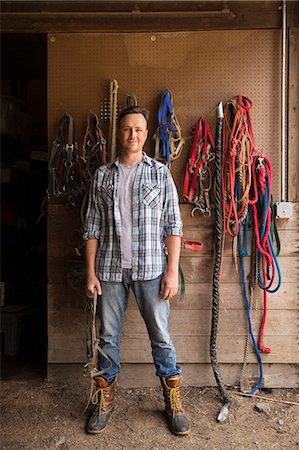 simsearch:6118-07235275,k - An organic farm in the Catskills. A man standing in a tack room in a stable. Foto de stock - Sin royalties Premium, Código: 6118-07203337