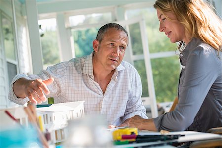 simsearch:6118-07203461,k - A farmhouse kitchen. A model of a house on the table. Designing a house. A couple. Stock Photo - Premium Royalty-Free, Code: 6118-07203449