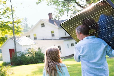 diy or home improvement - A man carrying a solar panel towards a building under construction. Foto de stock - Sin royalties Premium, Código: 6118-07203462