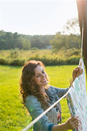 farmhouse - A woman hanging laundry on the washing line, in the fresh air. Stock Photo - Premium Royalty-Free, Code: 6118-07203470