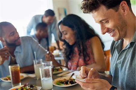 simsearch:6118-07203656,k - A group of men and women in a cafe, having drinks and enjoying each other's company. Fotografie stock - Premium Royalty-Free, Codice: 6118-07203490