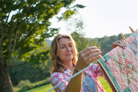 A woman hanging laundry on the washing line, in the fresh air. Stock Photo - Premium Royalty-Free, Code: 6118-07203413