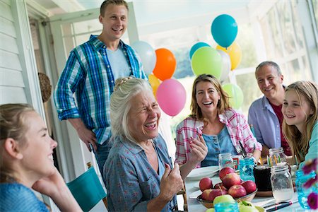 A birthday party in a farmhouse kitchen. A group of adults and children gathered around a chocolate cake. Photographie de stock - Premium Libres de Droits, Code: 6118-07203418