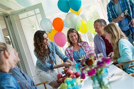 senior women social group - A birthday party in a farmhouse kitchen. A group of adults and children gathered around a chocolate cake. Stock Photo - Premium Royalty-Free, Code: 6118-07203419