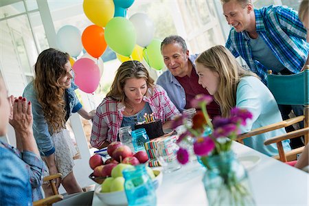 family gathering - A birthday party in a farmhouse kitchen. A group of adults and children gathered around a chocolate cake. Stock Photo - Premium Royalty-Free, Code: 6118-07203421