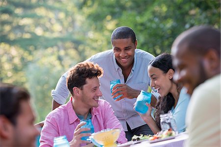 simsearch:6118-07235126,k - A group of people having a meal outdoors, a picnic. Men and women. Foto de stock - Royalty Free Premium, Número: 6118-07203550