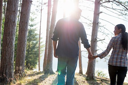 summer hairstyle - Lakeside. A couple walking in the shade of pine trees in summer. Stock Photo - Premium Royalty-Free, Code: 6118-07203566