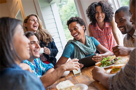 A group of people meeting in a cafe for a meal. Using digital tablets and smart phones. Foto de stock - Sin royalties Premium, Código: 6118-07203661