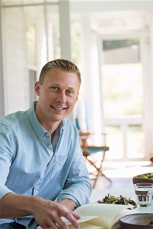 simsearch:6118-07203624,k - A man seated at a cafe table reading a book. Stock Photo - Premium Royalty-Free, Code: 6118-07203600