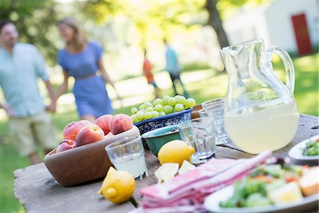 simsearch:6118-07781807,k - A summer buffet of fruits and vegetables, laid out on a table. People in the background. Stock Photo - Premium Royalty-Free, Code: 6118-07203623