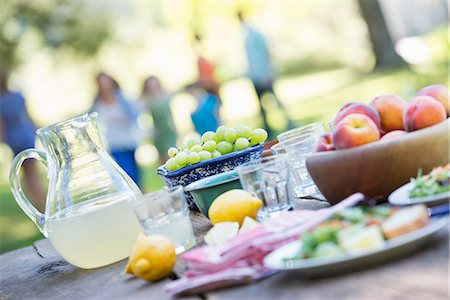 simsearch:6118-07203624,k - A summer buffet of fruits and vegetables, laid out on a table. People in the background. Stock Photo - Premium Royalty-Free, Code: 6118-07203626