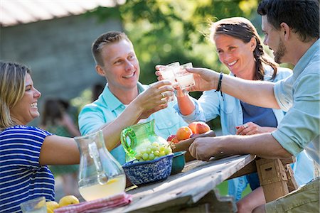 summer season - A family, adults and children seated around a table, enjoying a meal together. Stock Photo - Premium Royalty-Free, Code: 6118-07203631