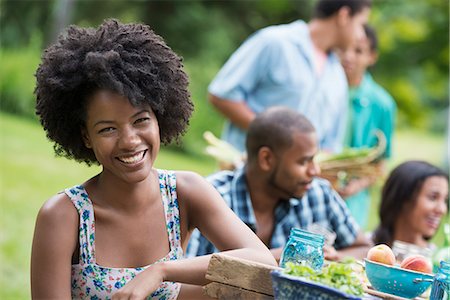 A group of adults and young people at a meal in the garden of a farmhouse. Stock Photo - Premium Royalty-Free, Code: 6118-07203758