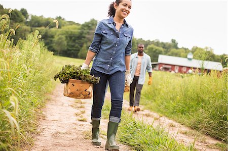 people rubber boots - Two people working on an organic farm. Carrying baskets of fresh picked vegetables. Photographie de stock - Premium Libres de Droits, Code: 6118-07203858