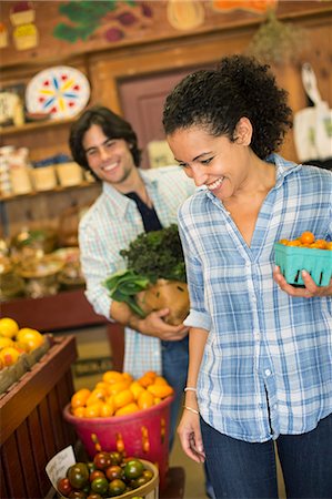 simsearch:6118-07235154,k - Two people with baskets of tomatoes and curly green leafy vegetables. Working on an organic farm. Foto de stock - Sin royalties Premium, Código: 6118-07203875