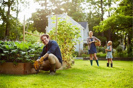 family backyard relaxing - Three people, two adults and a child in a vegetable garden. Stock Photo - Premium Royalty-Free, Code: 6118-07203931