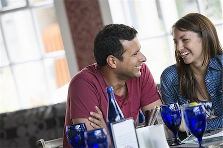 A cafe interior. A couple seated at a table. Stock Photo - Premium Royalty-Free, Code: 6118-07235076