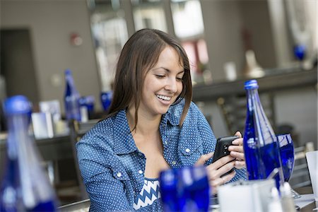 A woman seated in a cafe using a smart phone. Stockbilder - Premium RF Lizenzfrei, Bildnummer: 6118-07235089