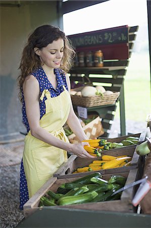 supermarket not indoors - An organic fruit and vegetable farm. A young woman sorting vegetables. Stock Photo - Premium Royalty-Free, Code: 6118-07235198