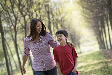 simsearch:6118-07235126,k - A woman and a child walking down an avenue of trees. Foto de stock - Royalty Free Premium, Número: 6118-07235111