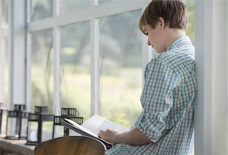 A young person sitting reading a book. Stock Photo - Premium Royalty-Free, Code: 6118-07235230