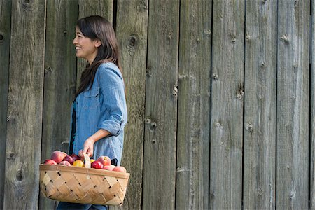 socializing - A woman carrying a basket of freshly picked fruit. Plums and peaches. Foto de stock - Sin royalties Premium, Código: 6118-07351193