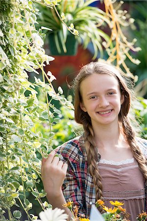Summer on an organic farm. A young girl in a plant nursery full of flowers. Stock Photo - Premium Royalty-Free, Code: 6118-07351128
