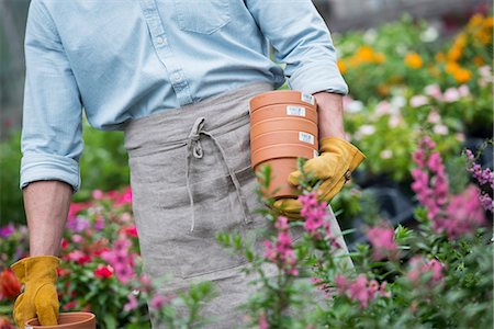 simsearch:6118-07521749,k - An organic flower plant nursery. A man carrying plant pots. Photographie de stock - Premium Libres de Droits, Code: 6118-07351242