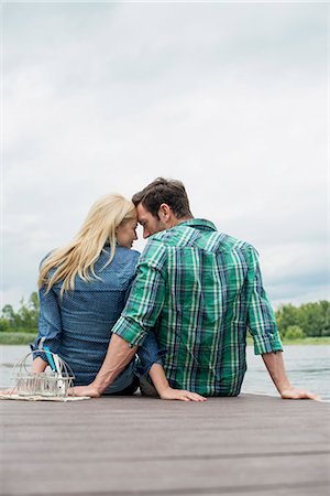 stoff - A man and woman seated on a jetty by a lake. Stockbilder - Premium RF Lizenzfrei, Bildnummer: 6118-07351264