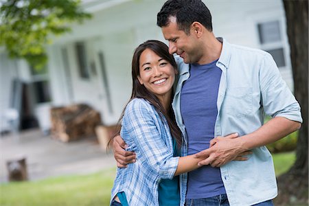 family backyard relaxing - A couple standing with arms around each other. Stock Photo - Premium Royalty-Free, Code: 6118-07351222