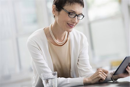 Young professionals at work. A woman in an office, using a digital tablet. Photographie de stock - Premium Libres de Droits, Code: 6118-07351366