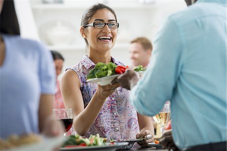 An open plan office in New York City. A working lunch, a salad buffet. A group of men and women of mixed ages and ethnicities meeting together. Stock Photo - Premium Royalty-Free, Code: 6118-07351452