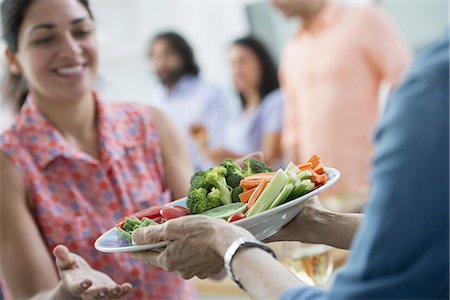 An open plan office in New York City. A working lunch, a salad buffet. A group of men and women of mixed ages and ethnicities meeting together. Photographie de stock - Premium Libres de Droits, Code: 6118-07351455