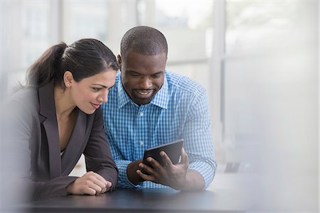 simsearch:6118-07351160,k - Professionals in the office. A light and airy place of work. Two people sitting at a desk, using a digital tablet. Work colleagues. Photographie de stock - Premium Libres de Droits, Code: 6118-07351463