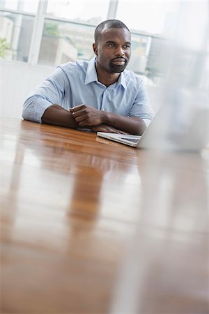 simsearch:6118-07122714,k - An office or apartment interior in New York City. A man seated at a table using a laptop computer. Foto de stock - Sin royalties Premium, Código: 6118-07351410