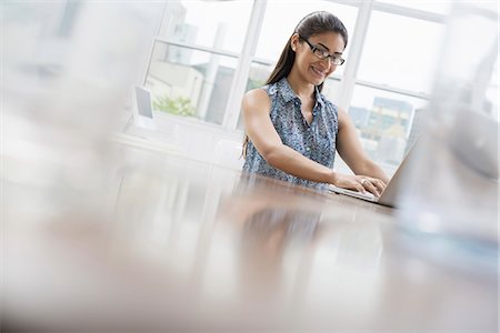 simsearch:6118-07351429,k - Business people. The office in summer. A young woman sitting comfortably in a quiet airy office environment. Using a laptop. Stock Photo - Premium Royalty-Free, Code: 6118-07351414