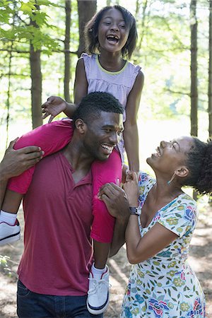 simsearch:6118-07351531,k - A family, two parents and a child sitting on her father's shoulders. Stock Photo - Premium Royalty-Free, Code: 6118-07351570