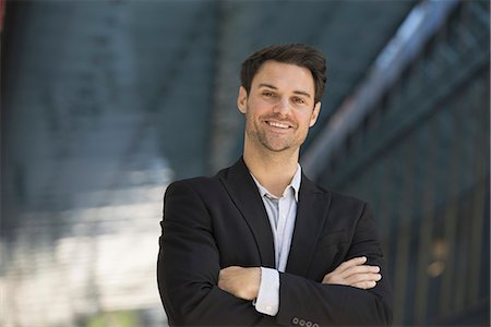 relaxed black man - Business people in the city. Keeping in touch on the move. A man in a black jacket and open collared shirt. Stock Photo - Premium Royalty-Free, Code: 6118-07351515