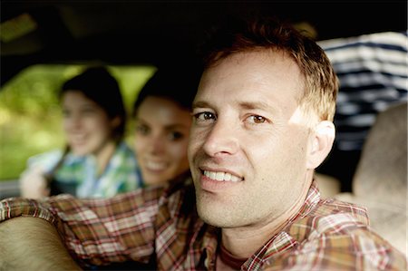 simsearch:6118-07353412,k - Three passengers in the cab of a pickup truck. One young man driving. Two young women sitting beside him. Foto de stock - Sin royalties Premium, Código: 6118-07351670