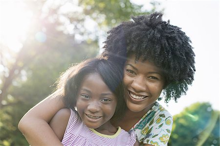 simsearch:6118-07351529,k - A young woman and a child hugging. Foto de stock - Sin royalties Premium, Código: 6118-07351600